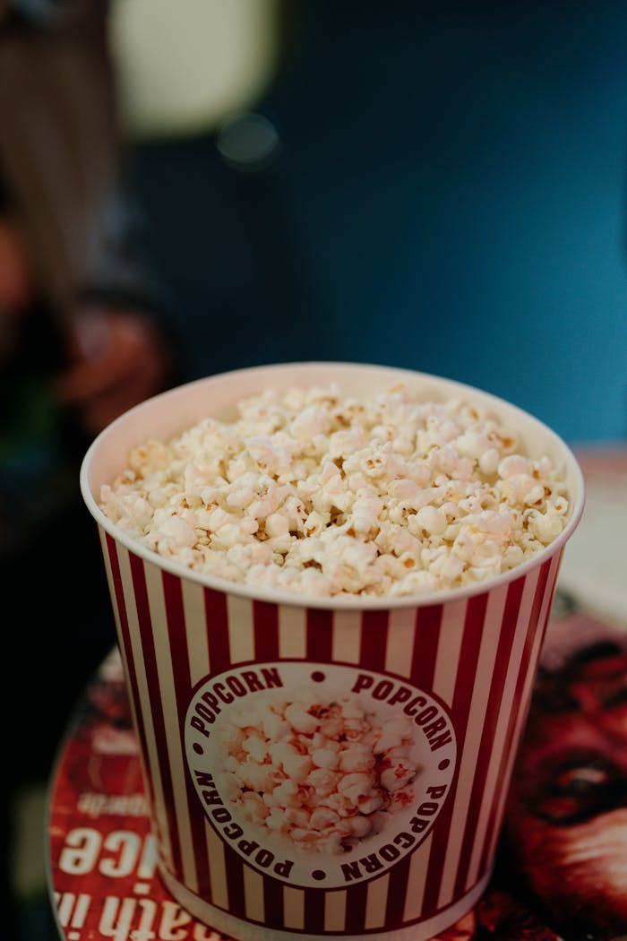 Delicious popcorn in a classic red and white bucket, perfect for movie nights.
